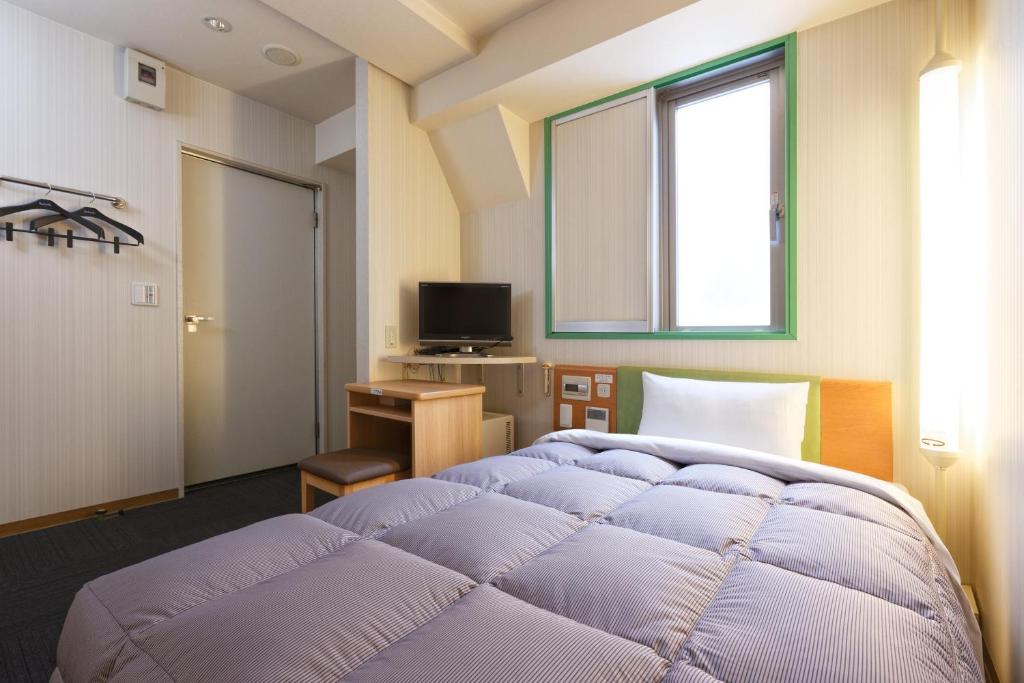 ein Schlafzimmer mit einem großen lila Bett und einem Fenster in der Unterkunft R&B Hotel Kobe Motomachi in Kōbe