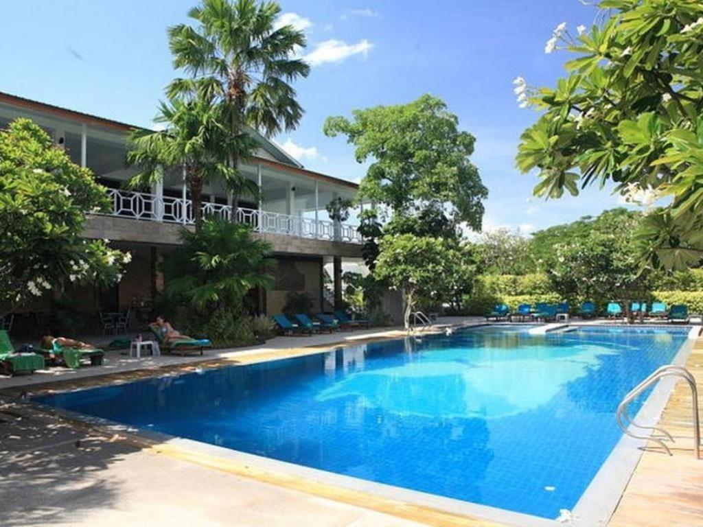 una piscina frente a un complejo en River Kwai Hotel en Kanchanaburi