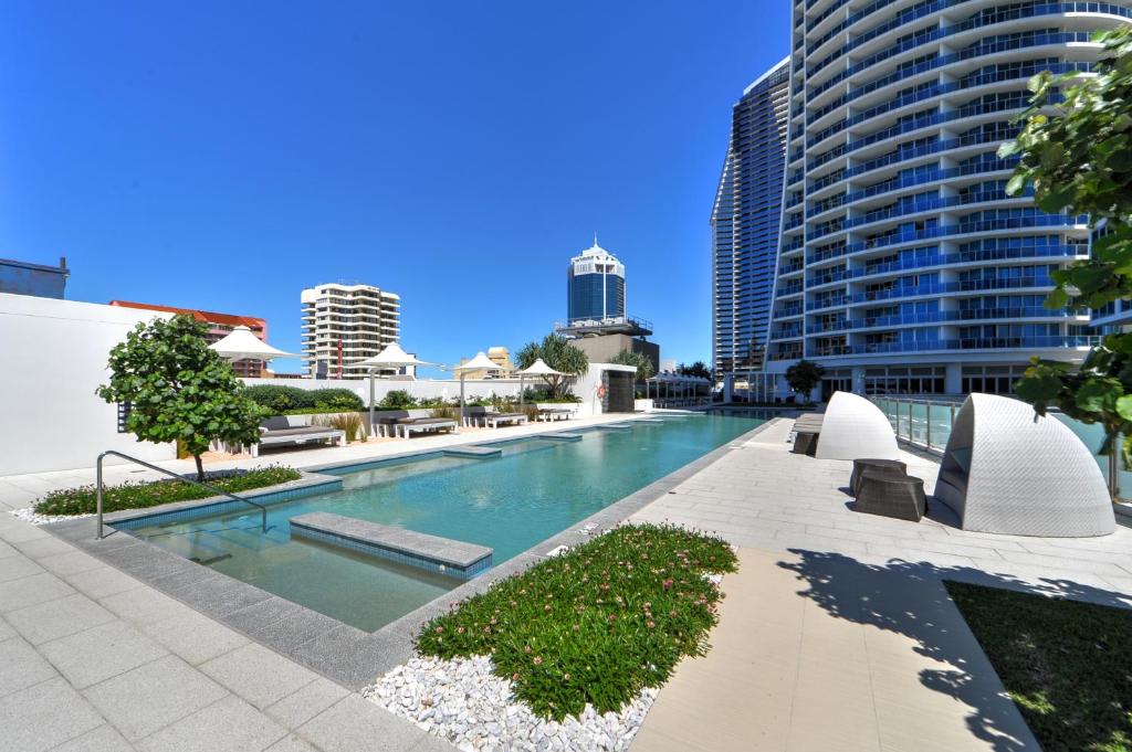 a swimming pool in a city with tall buildings at H-Residences - GCLR in Gold Coast