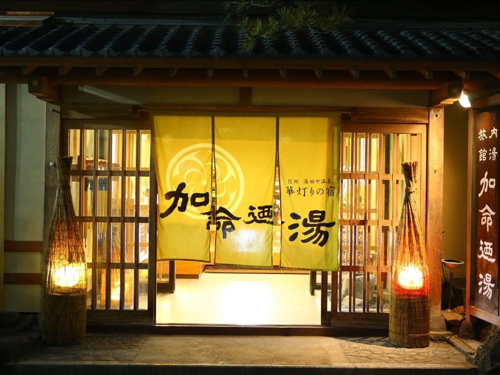 a front door of a building with chinese writing on it at Kamei no Yu in Yamanouchi