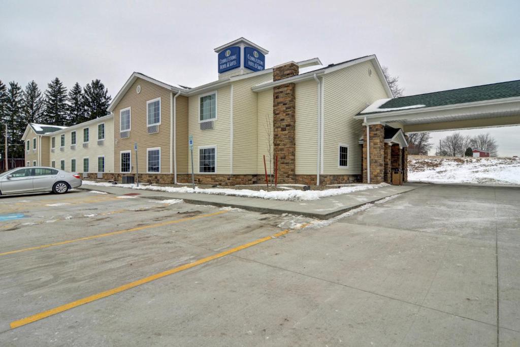 a building with a blue clock on top of it at Cobblestone Hotel & Suites - Punxsutawney in Punxsutawney