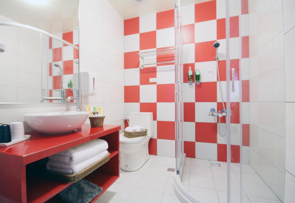 a bathroom with a red and white checkered wall at Bei Yue B&amp;B in Luodong