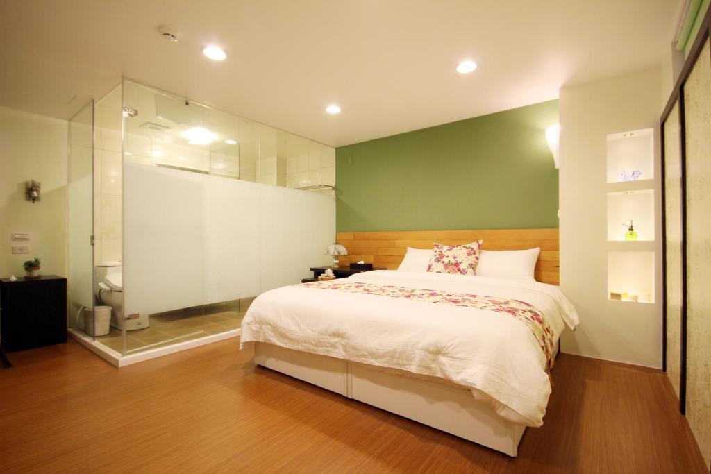 a bedroom with a large bed and a glass shower at Bei Yue B&amp;B in Luodong
