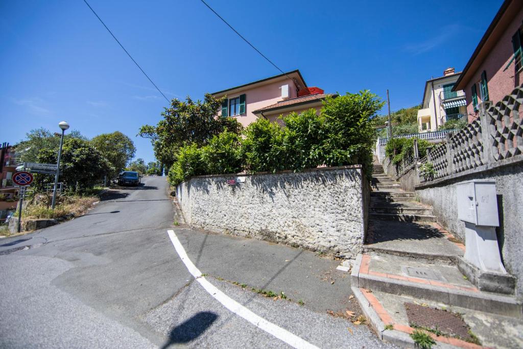 an empty street with a stone wall and houses at La Casa di Giada in La Spezia