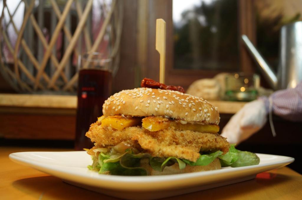 a chicken sandwich on a white plate on a table at Akazienhof Hotel & Brauhaus in Cologne