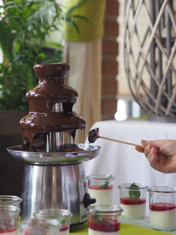 a person holding a wooden spoon in front of a coffee maker at Akazienhof Hotel & Brauhaus in Cologne