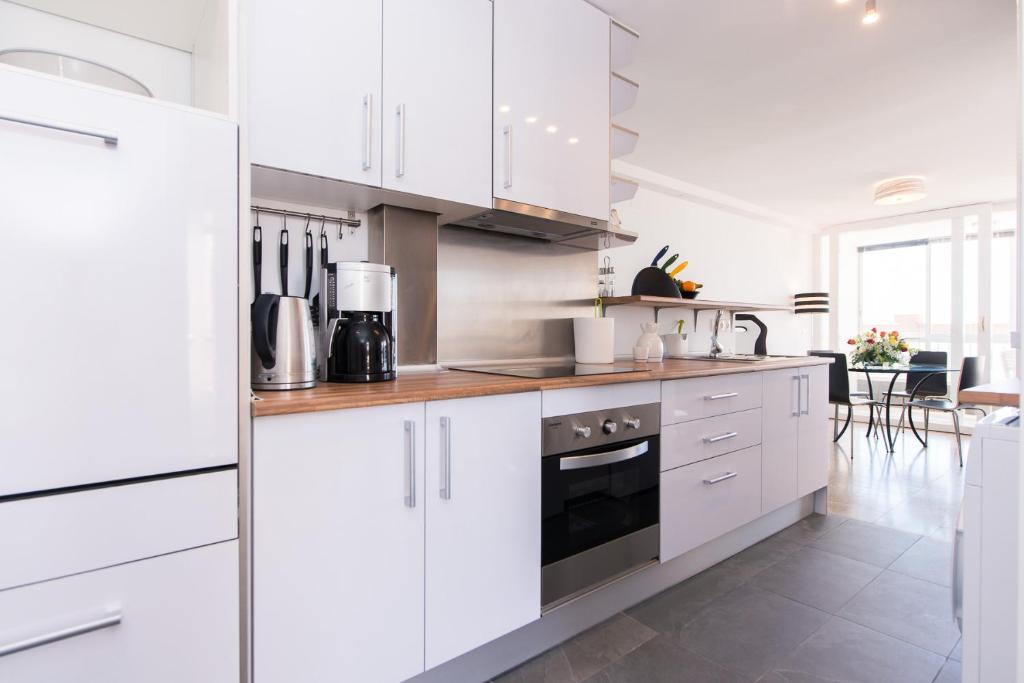 eine Küche mit weißen Schränken und einem Herd mit Backofen in der Unterkunft Two-Bedroom Apartment Diosa Tanit in Alicante