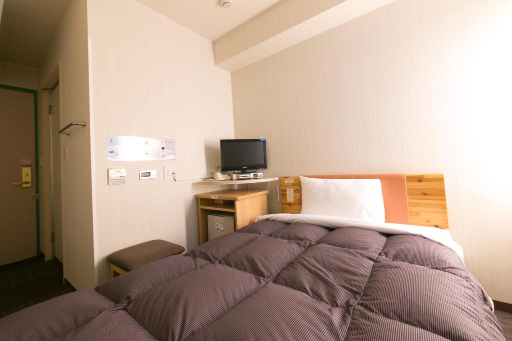 Postel nebo postele na pokoji v ubytování R&B Hotel Nagoya Sakae Higashi