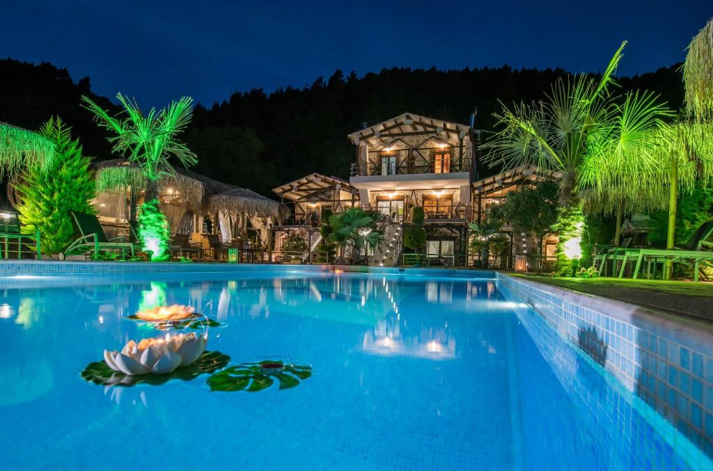 a house with a swimming pool at night at Simon King in Vourvourou