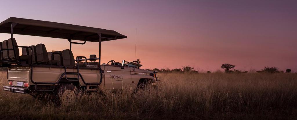 a safari vehicle parked in a field of tall grass at Monate Game Lodge in Modimolle