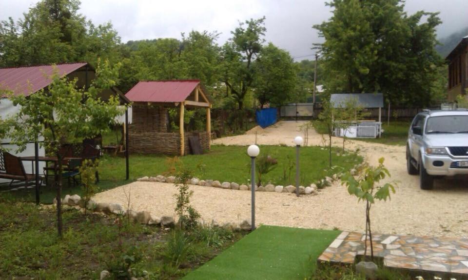 un jardin avec un kiosque et un parking. dans l'établissement Guest House Shavnabada, à Ambrolaouri