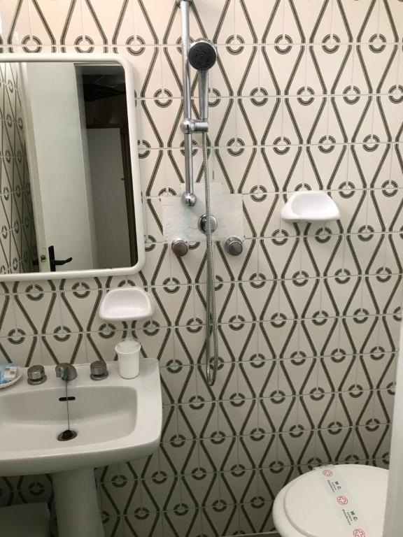 łazienka z białą umywalką i lustrem w obiekcie Hotel Perla Verde w Rimini