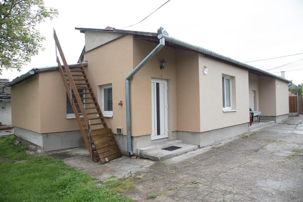 ein kleines Haus mit einer Treppe davor in der Unterkunft Ubytování Sýkora Apartments in Veľký Meder