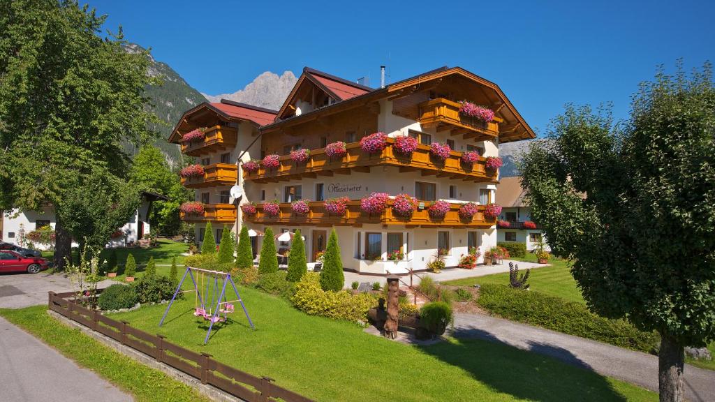 a large building with flower boxes on it at Hotel-Garni Weidacherhof in Leutasch