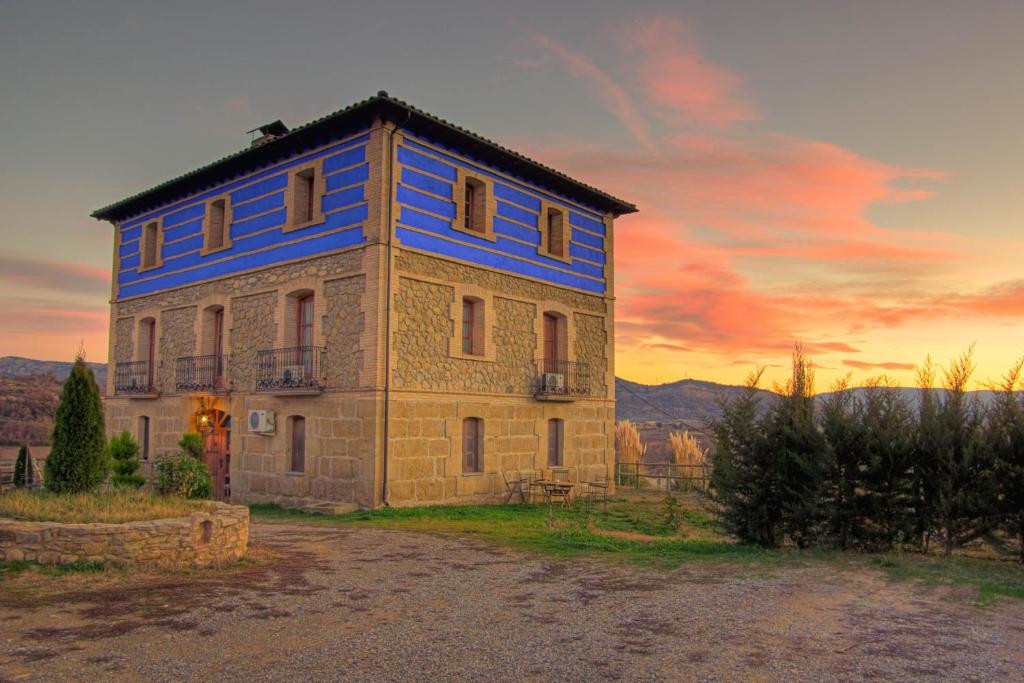 a house with a blue roof on top of it at Hotel Boutique Bodegas De Arnes - Adults Only in Graus