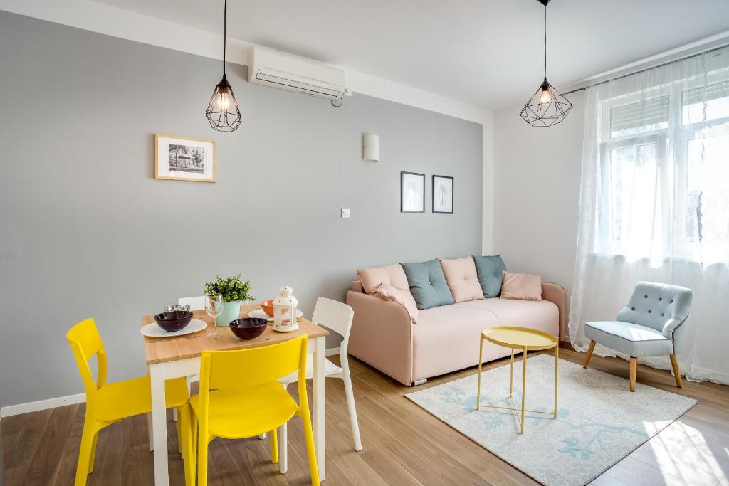 a living room with a table and yellow chairs at Apartment Argo in Zagreb