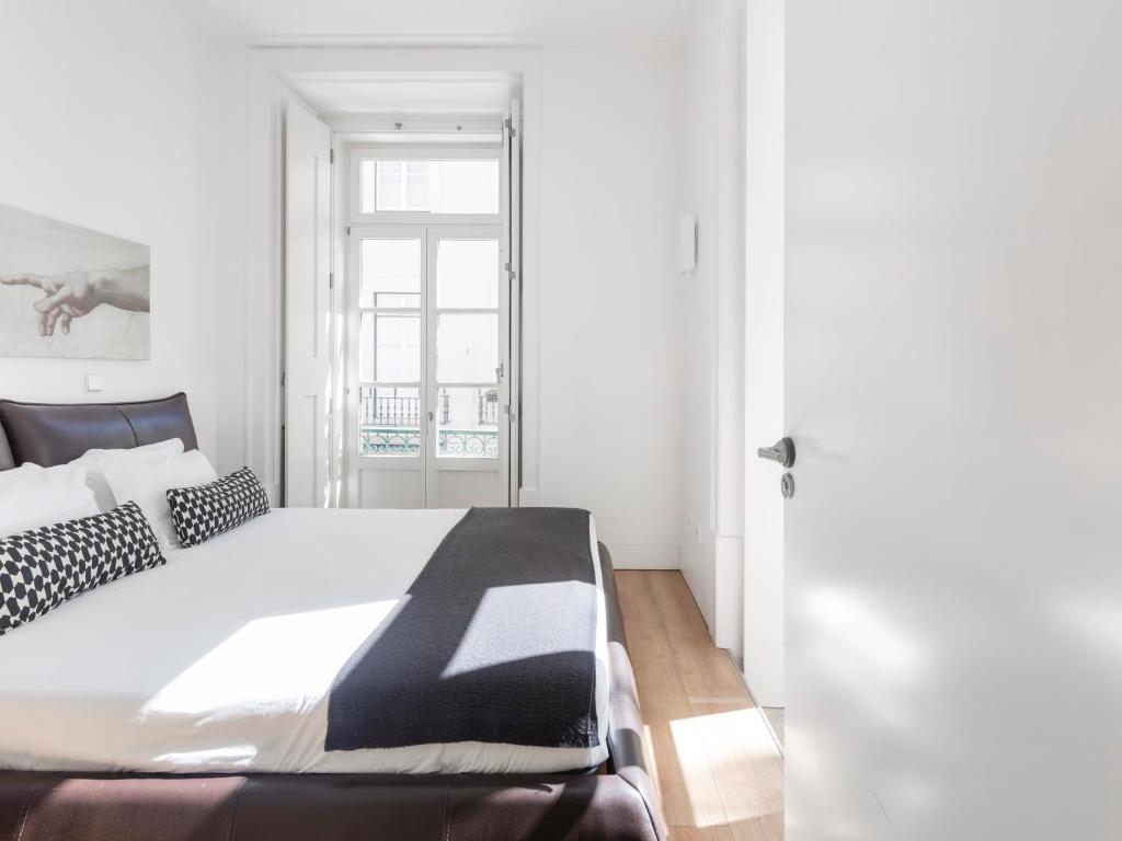 um quarto com uma cama grande e almofadas pretas e brancas em Lisbon Serviced Apartments - Baixa em Lisboa