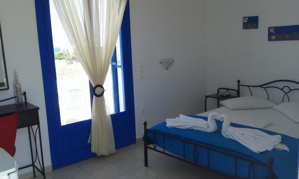 a bedroom with a bed with a blue door and a window at Vigles in Adamantas