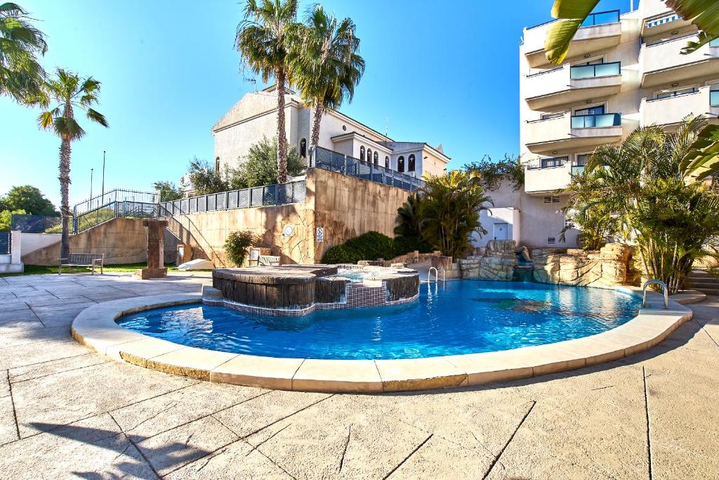 a swimming pool with a fountain in front of a building at Espanhouse La Zenia 109 in Orihuela Costa