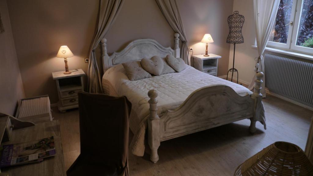 una camera con un letto bianco con due lampade sui tavoli di Chambres d'hôtes L'Ecrin des Saveurs a Schwenheim