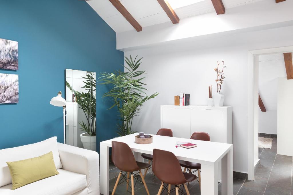 un soggiorno con tavolo e sedie bianchi di Carretas Attics Apartments a Madrid