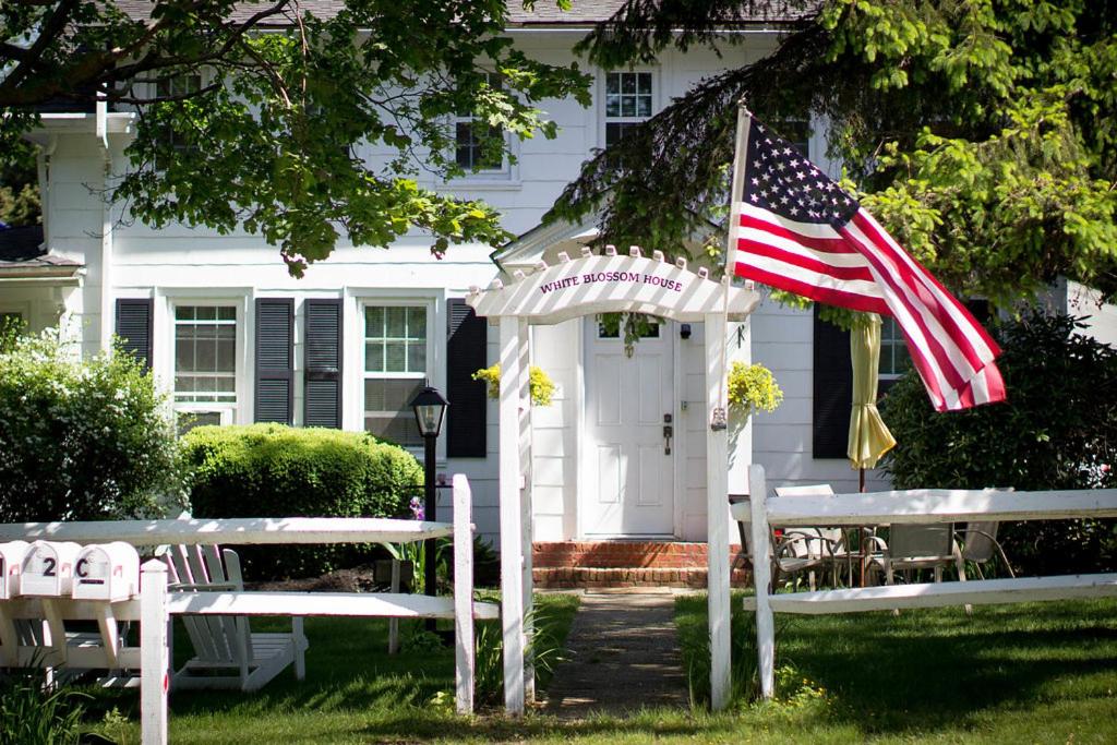 una bandera americana ondeando delante de una casa en Historic White Blossom House, en Southold