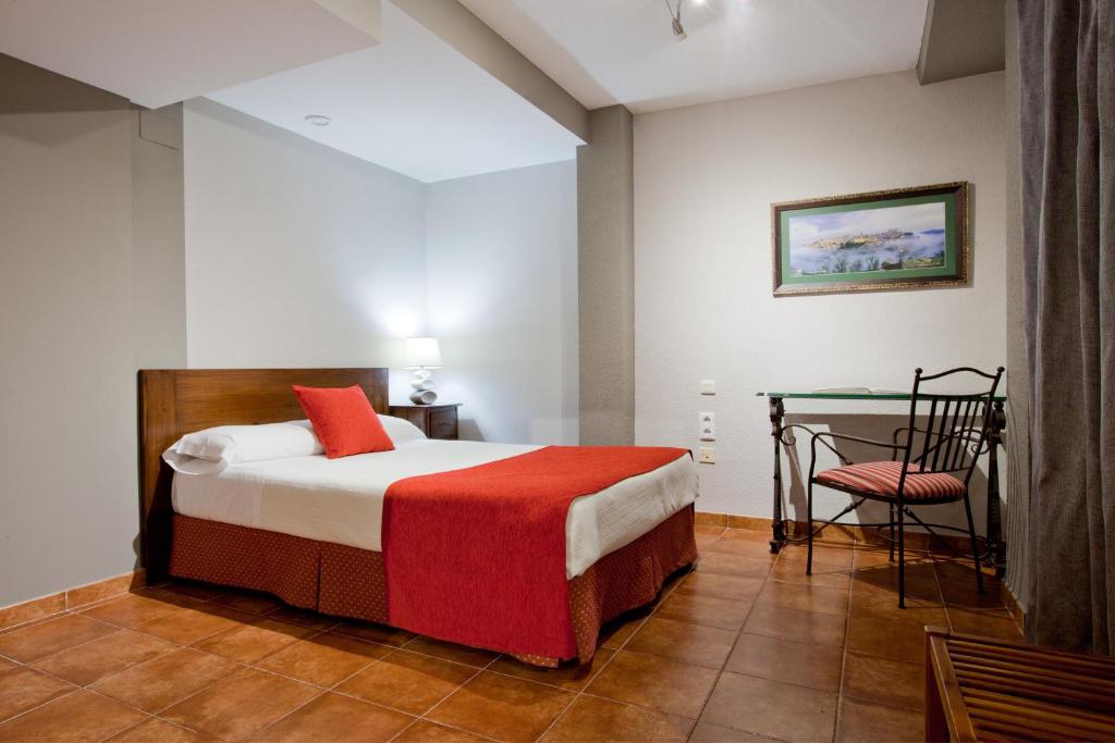 Postel nebo postele na pokoji v ubytování Hotel Real De Toledo