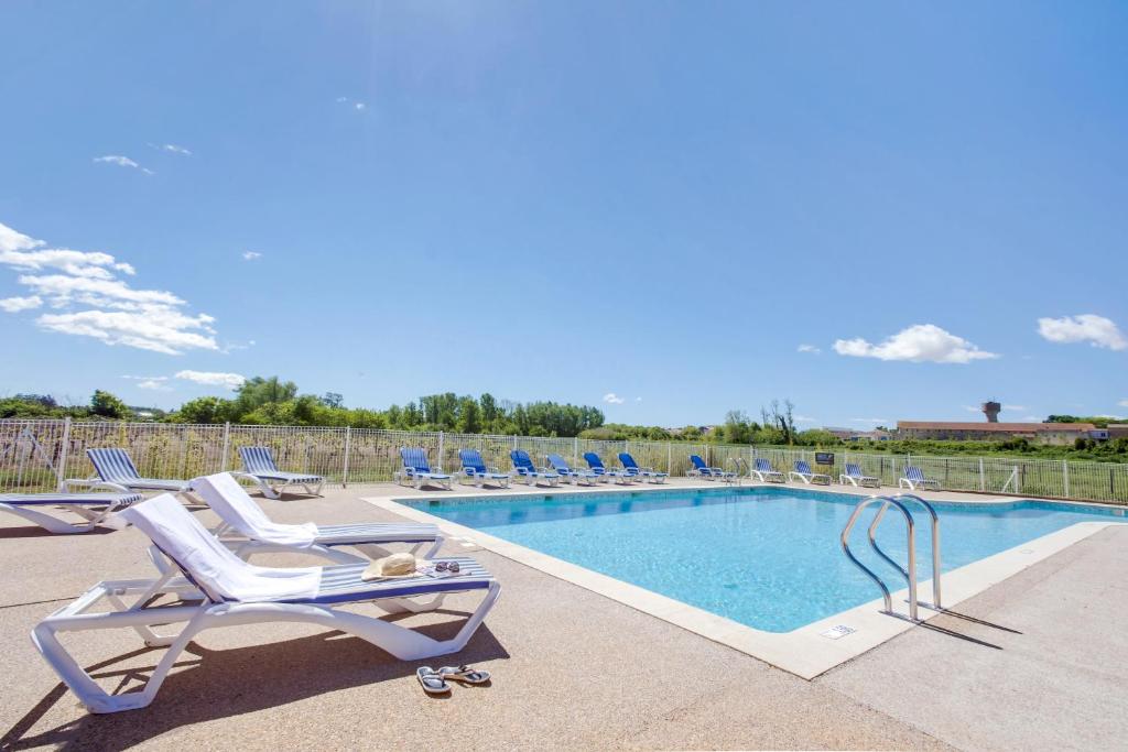 una piscina con sedie a sdraio e una piscina di Vacancéole - Le Domaine d'Enserune a Colombiers