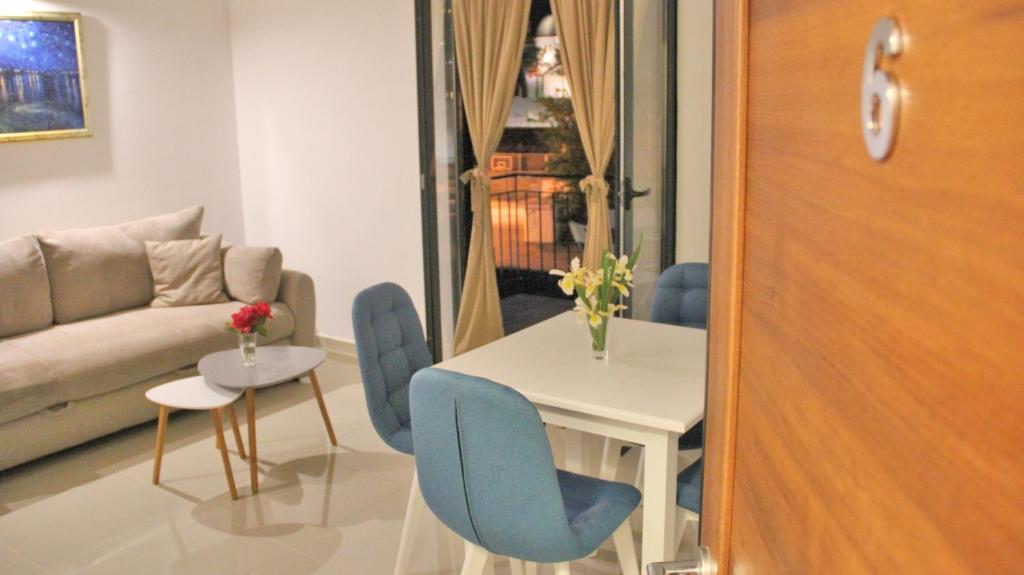 sala de estar con mesa, sillas y sofá en Filipa Apartment, en Kotor