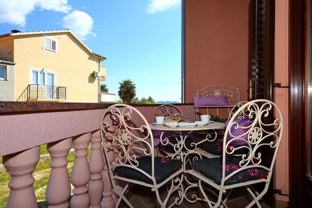 a balcony with two chairs and a table on a balcony at Villa Dalmatino in Pakoštane