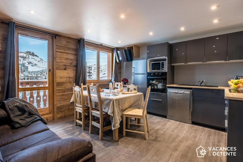 une cuisine et une salle à manger avec une table et des chaises dans l'établissement Tignes 301, à Tignes