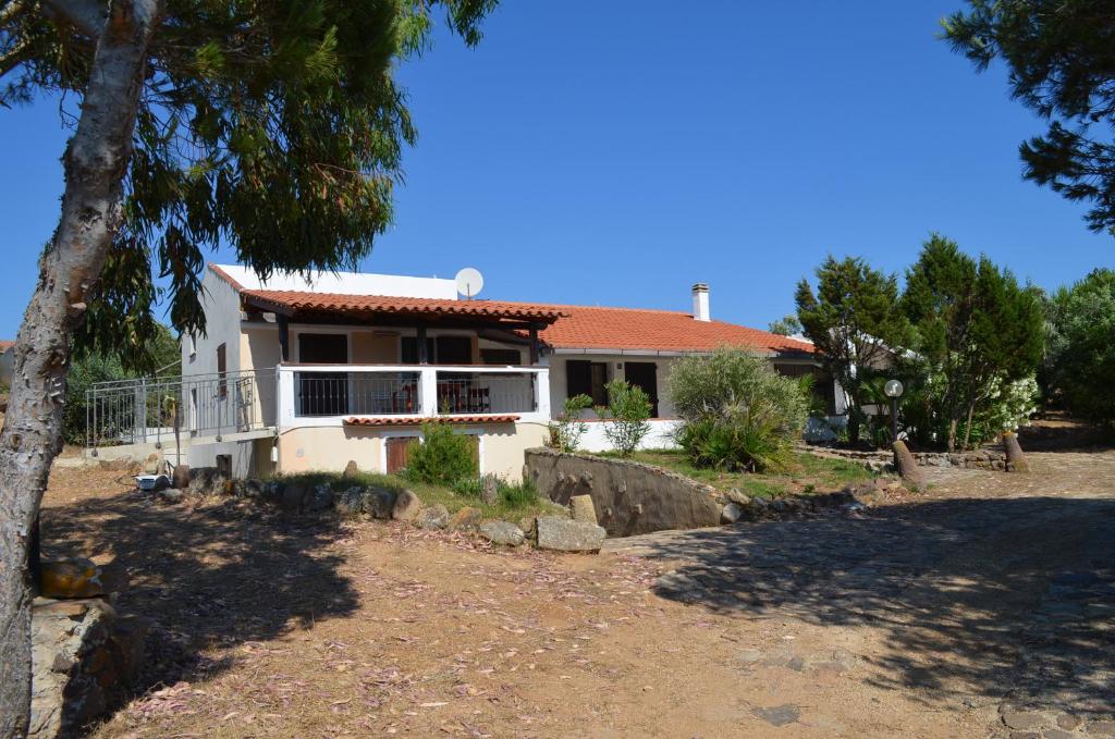 une maison blanche avec un arbre en face dans l'établissement Casa Vacanze Cala Sapone, à SantʼAntìoco