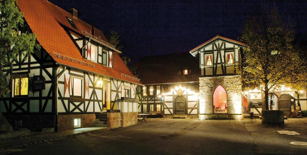 um edifício antigo com luzes acesas à noite em Hotel Der Grischäfer em Bad Emstal