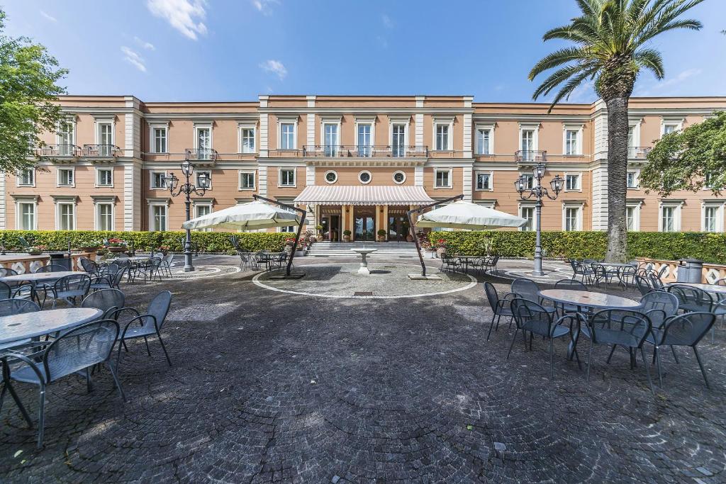 um grupo de mesas e cadeiras em frente a um edifício em Grand Hotel Telese em Telese Terme
