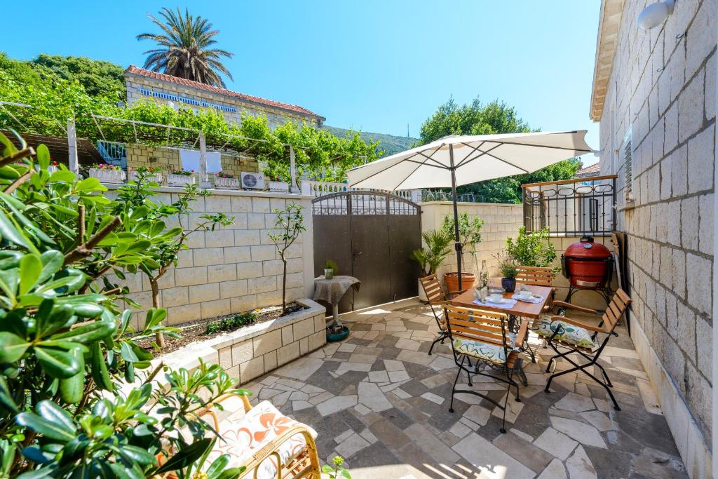 a patio with a table and chairs and an umbrella at Apartment Antonella in Dubrovnik