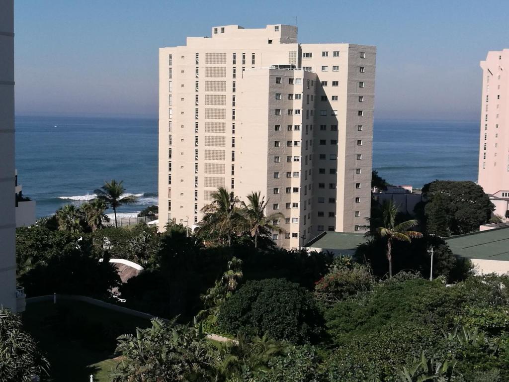 a large white building with the ocean in the background at 404 Ipanema Beach in Durban