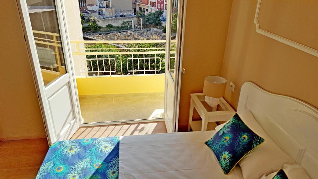 a bedroom with a bed and a window with a view at Colibrì Prestige Rooms - Roman Ruins View in Cagliari