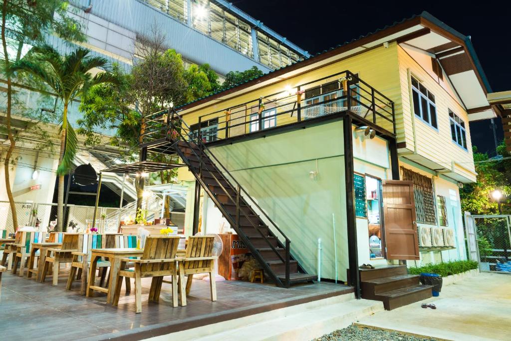 a restaurant with a staircase leading up to a building at NTY Hostel Near Suvarnabhumi Airport in Bangkok