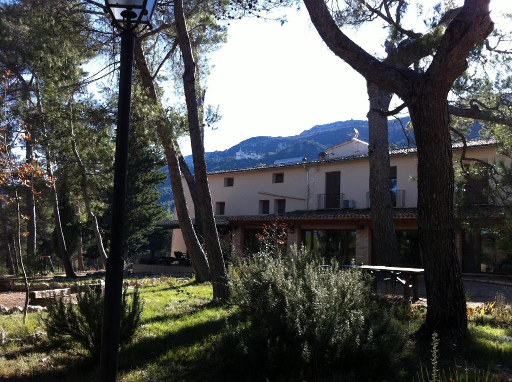 a building in the middle of a field with trees at Masía La Safranera in Alcoy