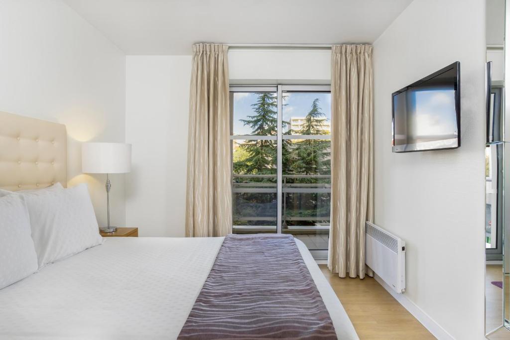 1 dormitorio con cama y ventana grande en Royal Regency Paris Vincennes, en Vincennes