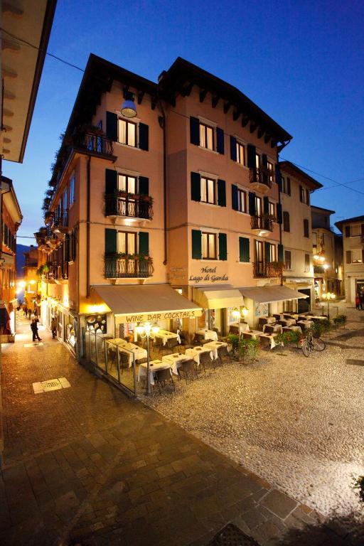 マルチェージネにあるHotel Lago Di Gardaの目の前にテーブルと椅子が置かれた建物