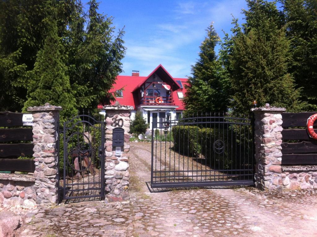 una puerta a una casa con techo rojo en Kapitańskie Gniazdo, en Czaplinek