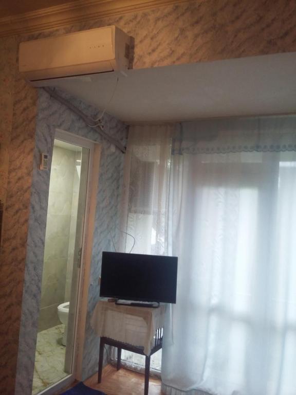 a living room with a television and a window at Guest House TiAni in Kobuleti