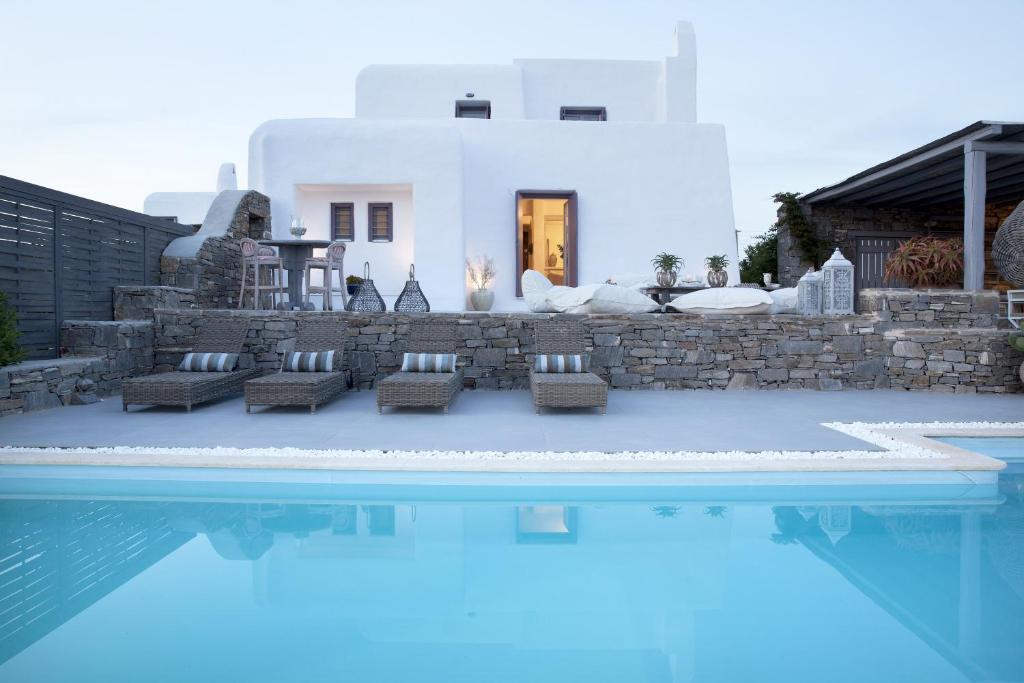 a villa with a pool in front of a house at Alfa Luxury Villas in Chrissi Akti