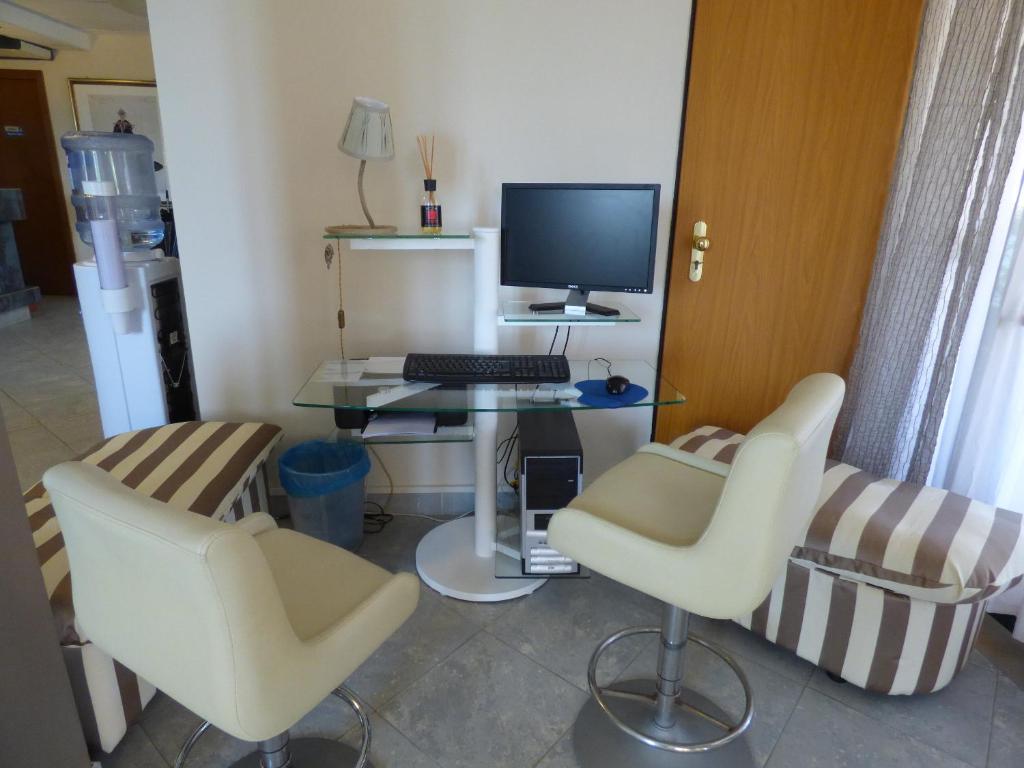 a room with a desk with a computer and two chairs at Hotel Turandot in Torre del Lago Puccini