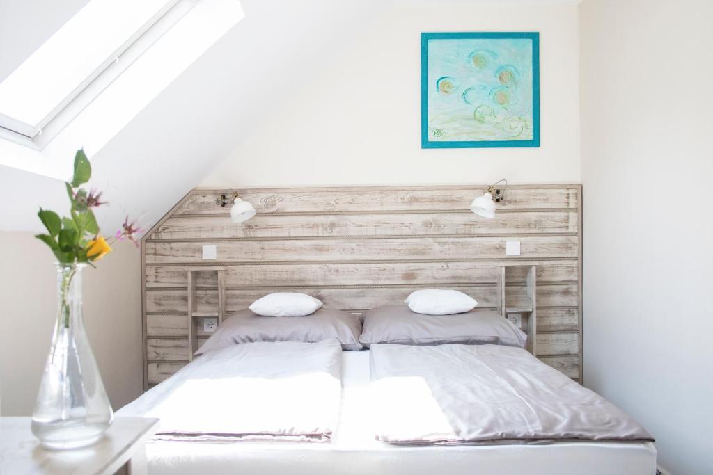 - une chambre avec un lit et une tête de lit en bois dans l'établissement Fészek -Étel és Hotel-, à Zánka