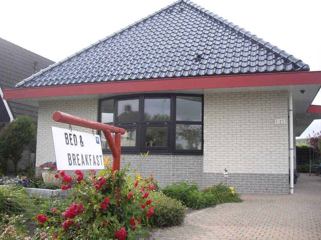 ein Schild vor einem Haus mit einem nicht gegrillten Schild in der Unterkunft Bed & Breakfast aan Zee in Callantsoog