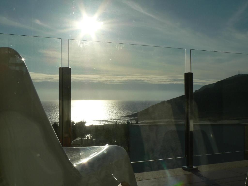 una ventana de cristal con vistas al océano. en Hotel Naturaleza Mar da Ardora Wellness & Spa en Finisterre