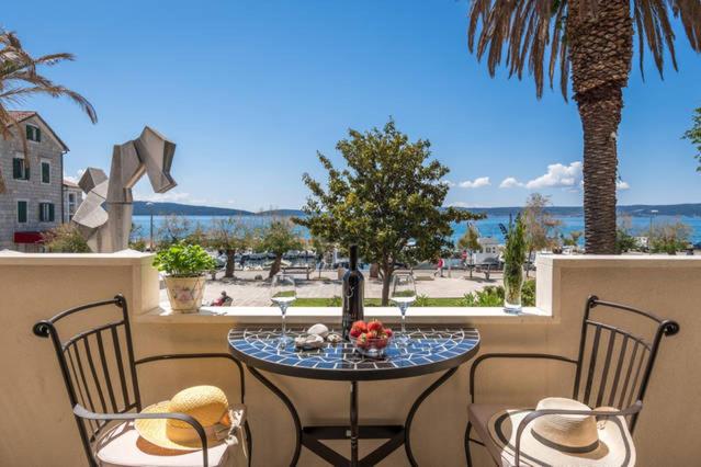 a table and chairs on a balcony with a view of the ocean at Apartment Dujić with hot tub in Kaštela