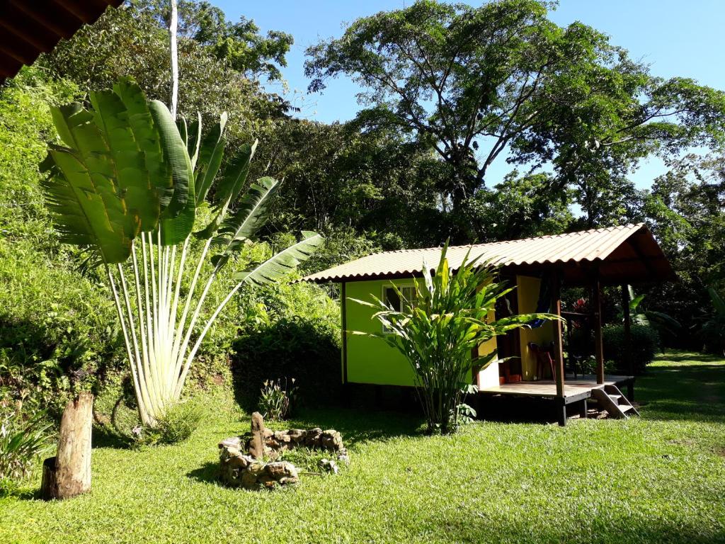 una pequeña casa verde en un patio con árboles en Casita Rio Indio, en Nombre de Dios